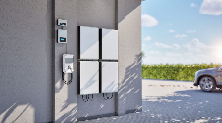 A modern home exterior featuring an integrated system of solar battery storage units and an electric vehicle charging station, showcasing the advanced energy solutions provided by Mizo Electric in North County San Diego.