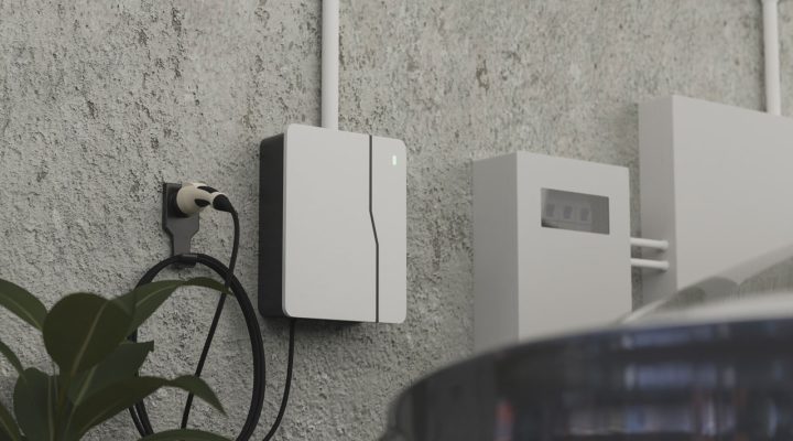 A minimalist outdoor installation of a white electric vehicle charger and home battery backup system mounted on a concrete wall, providing a modern and efficient energy solution for homeowners in San Diego County.