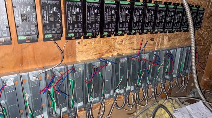 The intricate wiring behind a large-scale commercial lighting control system, featuring multiple drivers and controllers. This image highlights the technical skill and organized workmanship of Mizo Electric on complex business projects.