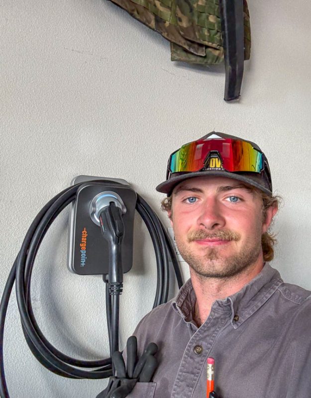 A proud Mizo Electric technician standing next to a newly installed ChargePoint Home Flex EV charger, showcasing our expertise in providing reliable and smart charging solutions for electric vehicle owners in North County San Diego.